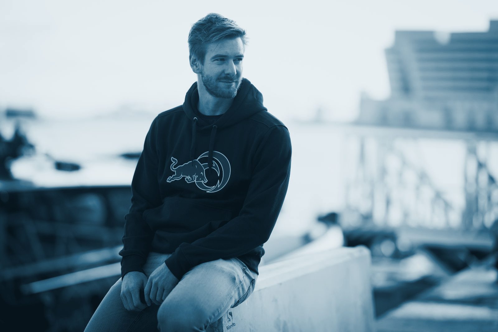 Barnabé Delarze sitting on a harbour wall in Barcelona