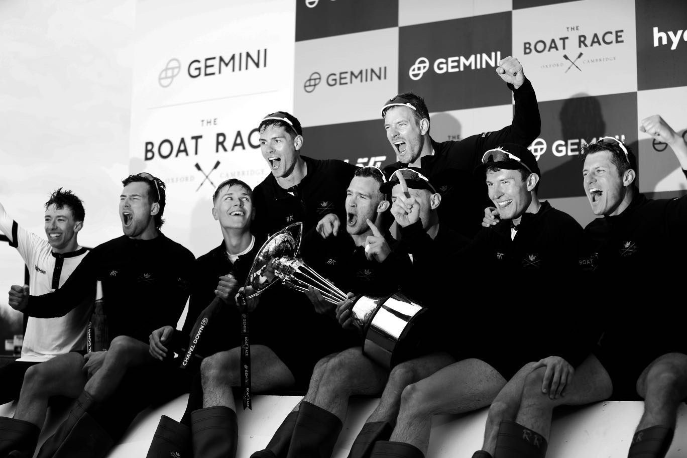 The Oxford crew celebrating with the trophy, in black and white