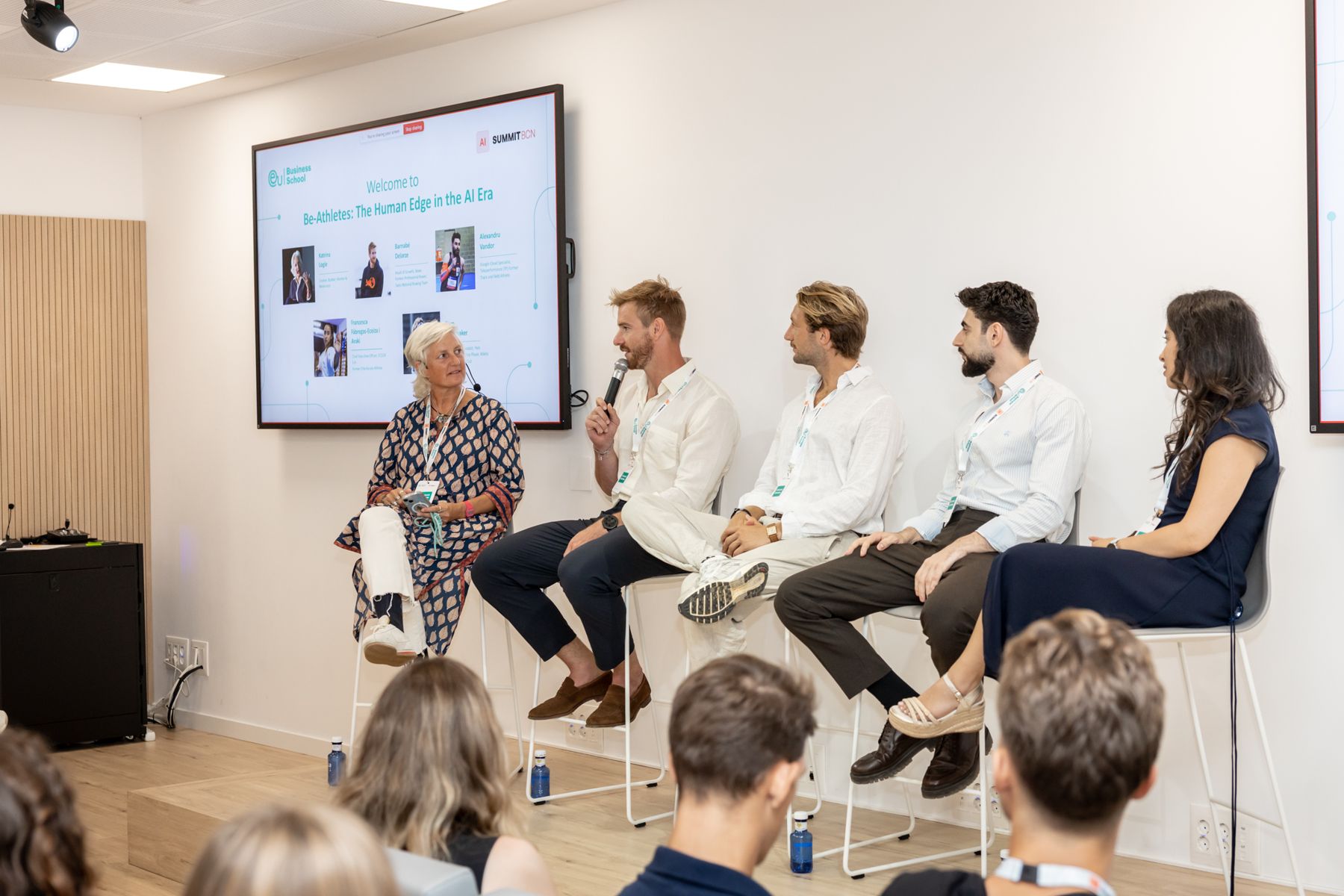 A panel of speakers seated in front of an audience